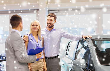 Image showing happy couple with car dealer in auto show or salon