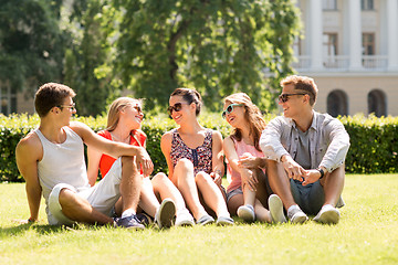 Image showing group of smiling friends outdoors sitting on grass