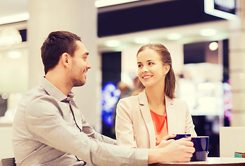 Image showing happy couple with shopping bags drinking coffee