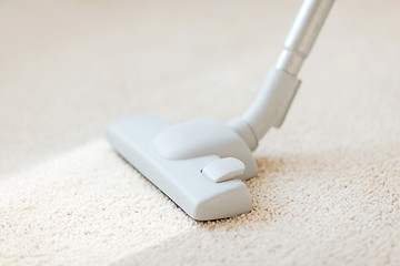 Image showing close up of male hoovering carpet
