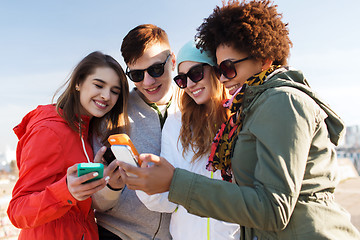 Image showing smiling friends with smartphones