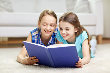 Image showing two happy girls reading book at home