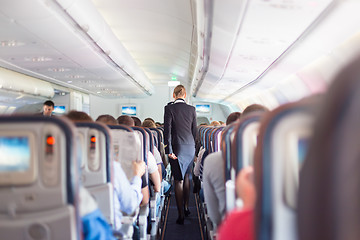 Image showing Stewardess and passengers on commercial airplane.