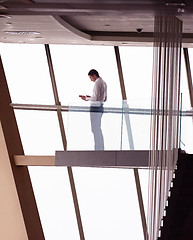 Image showing young successful business man in penthouse apartment working on 