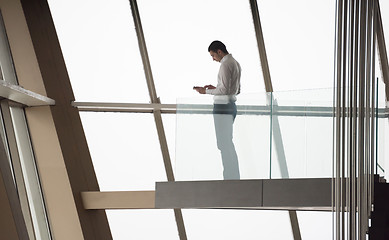 Image showing young successful business man in penthouse apartment working on 