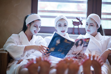 Image showing bachelorette party in spa, girls with face mask reading magazine