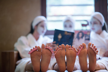 Image showing bachelorette party in spa, girls with face mask reading magazine