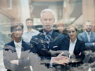 Image showing double exposure of senior business man with his team at office