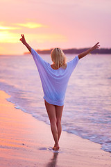 Image showing Lady on sandy tropical beach at sunset.