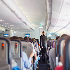 Image showing Stewardess and passengers on commercial airplane.
