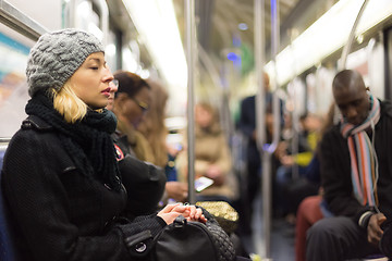 Image showing Woman napping on subway full of people.