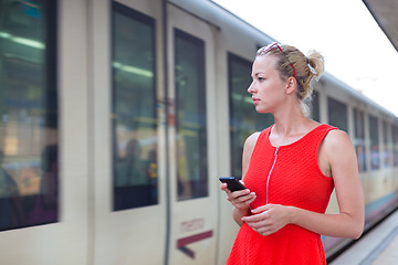 Image showing Young woman on platform of railway station.