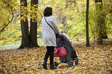 Image showing woman with pram in autumnal park