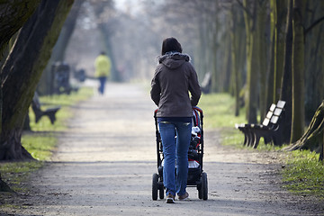 Image showing woman with pram in autumnal park