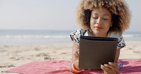 Image showing Woman Uses A Tablet On The Beach