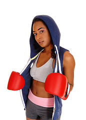 Image showing African woman in hoodie and red boxing cloves.