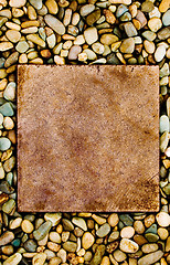 Image showing Stone slab surrounded by grungy pebbles

