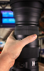 Image showing Detective holding big zoom lens\r