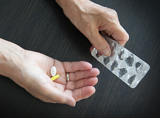 Image showing Elderly person taking medication