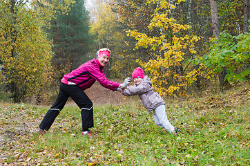 Image showing Woman with girl doing aerobics in the autumn park