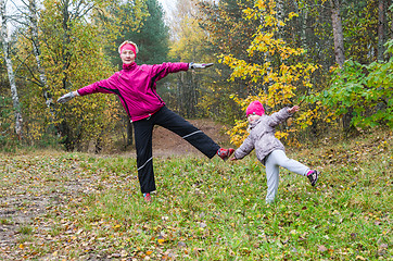 Image showing Woman with girl doing aerobics in the autumn park