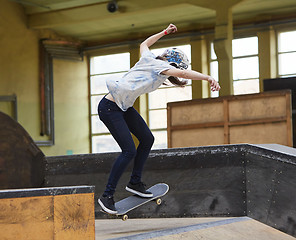 Image showing Teen female skater jumping high indoors