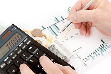 Image showing calculator, charts, pen in hand, business cards, money, workplac