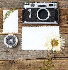 Image showing mockup stillife with retro photo, camera, lens and pressed plant