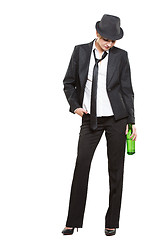 Image showing businesswoman wearing a hat and tie, holding bottle of alcohol. Isolated on white background