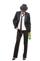 Image showing businesswoman wearing a hat and tie, holding bottle of alcohol. Isolated on white background