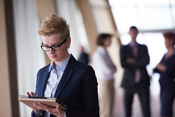 Image showing business woman with glasses  at office with tablet  in front  as