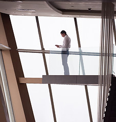 Image showing young successful business man in penthouse apartment working on 