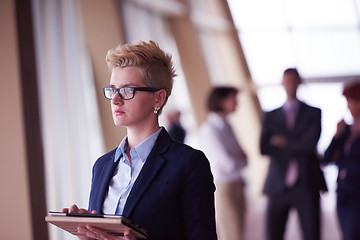 Image showing business woman with glasses  at office with tablet  in front  as