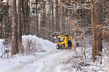 Image showing The tractor clears snow from the road