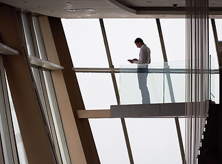 Image showing young successful business man in penthouse apartment working on 