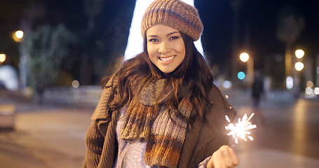 Image showing Pretty young woman celebrating with a sparkler