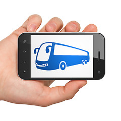 Image showing Travel concept: Hand Holding Smartphone with Bus on display