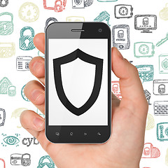 Image showing Privacy concept: Hand Holding Smartphone with Contoured Shield on display