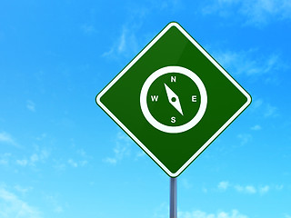 Image showing Travel concept: Compass on road sign background