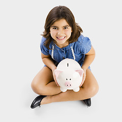 Image showing Young girl holding a piggybank