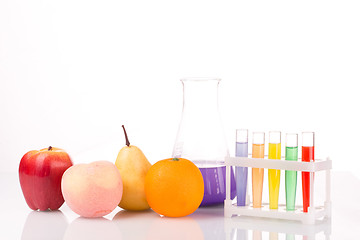 Image showing Fruit close chemical test tubes. Genetic Engineering. pesticides in foods