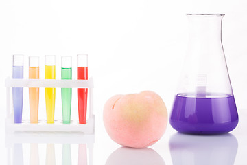 Image showing Fruit close chemical test tubes. Genetic Engineering. pesticides in foods