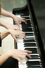 Image showing Women\'s hands on the keyboard of piano. girl plays music 