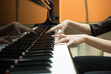 Image showing Women\'s hands on the keyboard of piano. girl plays music 