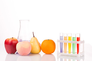 Image showing Fruit close chemical test tubes. Genetic Engineering. pesticides in foods