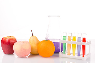 Image showing Fruit close chemical test tubes. Genetic Engineering. pesticides in foods