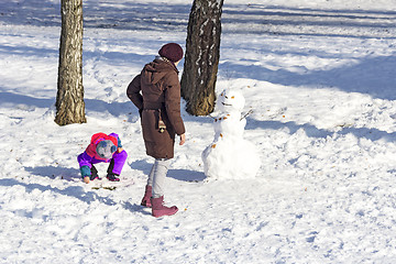 Image showing Mom and daughter make snowmen