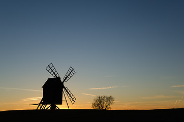 Image showing Old windmill silhouette by sunset