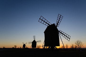 Image showing Silhouettes of old windmills by sunset