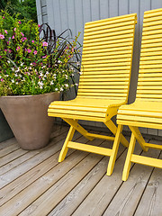 Image showing Patio decorated with yellow chairs and flowers